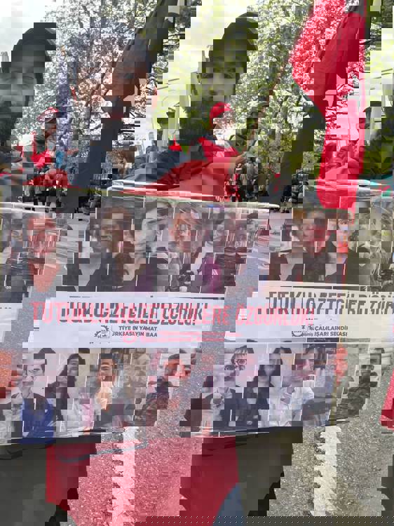 A DİSK member displaying a banner demanding the release of jailed journalists. (Evrim Kepenek/bianet)