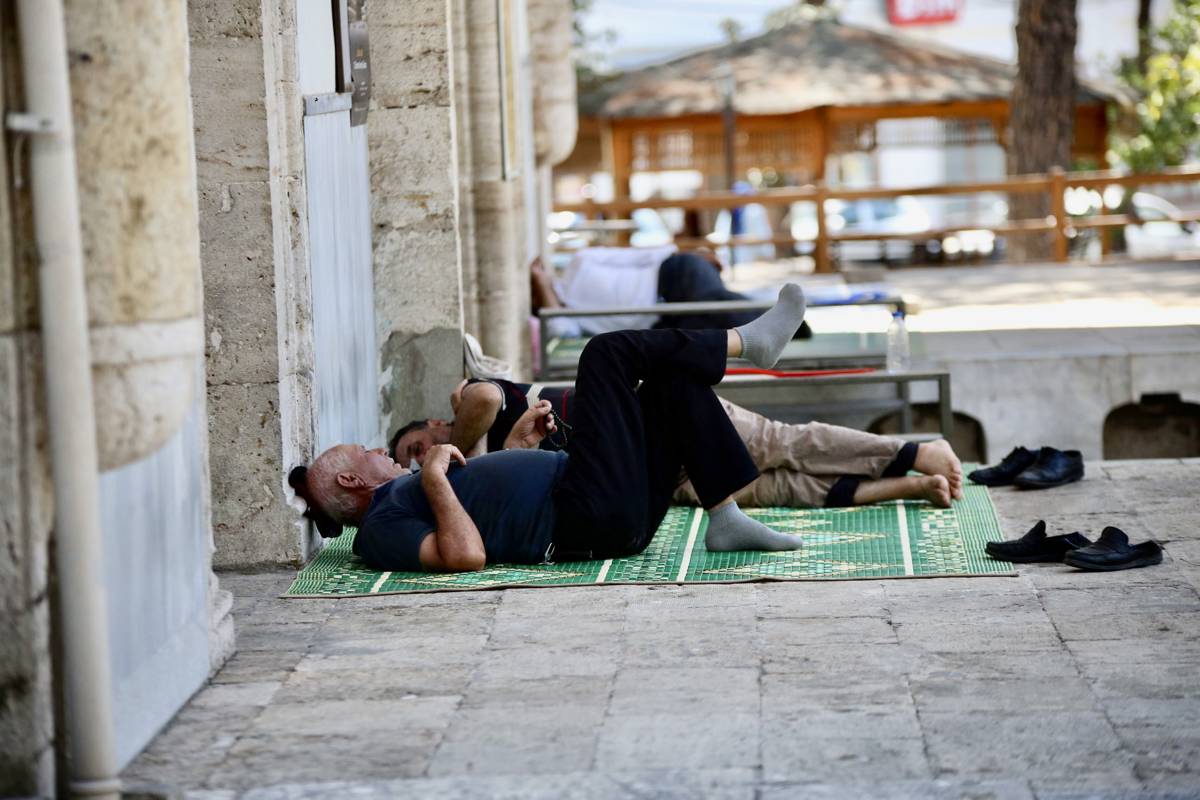 Men sleeping in the yard of a mosque in Aydın