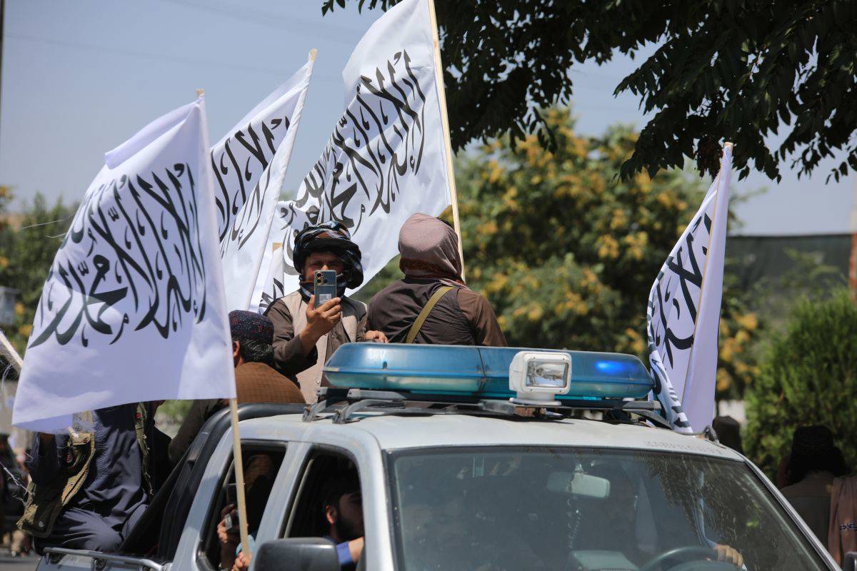 Fotoğrafta, Taliban üyeleri bir kamyonetin üstünde kutlama yapıyor