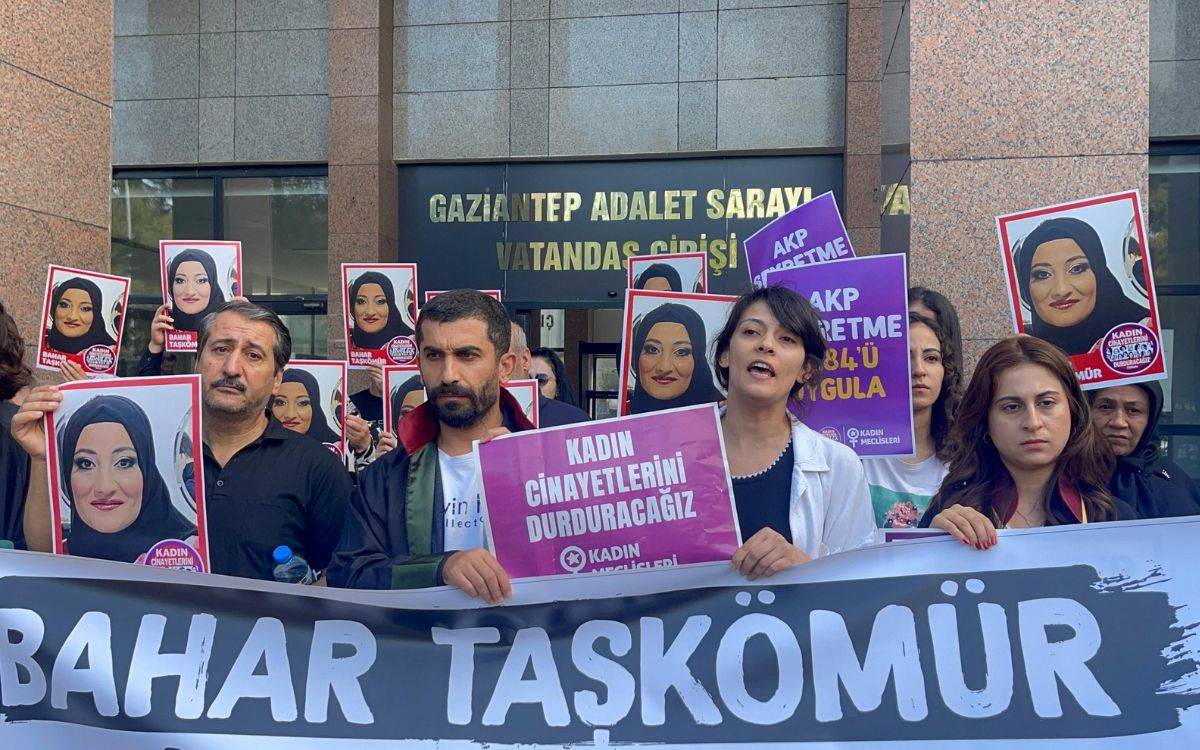 Bu fotoğrafta, bir grup insan Gaziantep Adalet Sarayı'nın önünde toplanmış ve protesto düzenliyor. Katılımcılar, ellerinde Bahar Taşkömür’ün fotoğrafının olduğu pankartlar ve afişler taşıyor. Bahar Taşkömür’ün bir kadın cinayeti mağduru olduğunu belirten afişlerin yanı sıra, “Kadın cinayetlerini durduracağız” ve “AKP şiddetme, 6284’ü uygula” yazılı pankartlar dikkat çekiyor. Grup, kadın cinayetlerine karşı toplumsal duyarlılığı artırmayı ve adalet talep etmeyi amaçlıyor. Katılımcıların yüz ifadeleri ciddi ve kararlı, arka planda ise "Gaziantep Adalet Sarayı Vatandaş Girişi" yazısı görünüyor. Fotoğraf, kadın cinayetlerine karşı toplumsal mücadeleyi ve adalet talebini yansıtıyor.