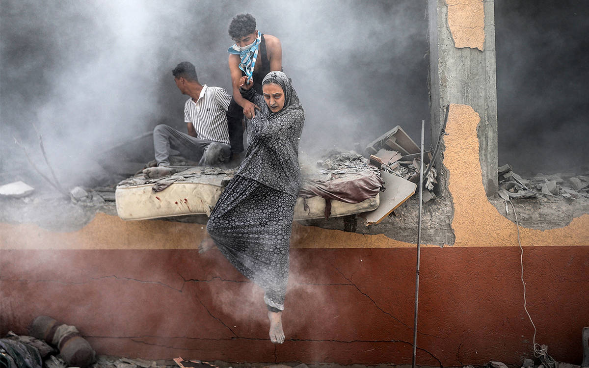 Bu fotoğrafta, yoğun duman ve yıkımın ortasında bir kadın, bir yapının yarı yıkılmış duvarından aşağıya doğru inerken görülüyor. Kadına yardımcı olan biri, elinden tutarak onu güvenli bir şekilde aşağıya indirmeye çalışıyor. Arkada başka bir kişi, harabeye dönüşmüş binanın kenarında oturmuş bir şekilde duruyor. Fotoğrafın genel atmosferi savaş ve yıkımın ortasında bir kurtuluş anını yansıtıyor. Bina harap olmuş, etraf toz ve enkaz içinde. Kadının üzerindeki uzun, geleneksel elbise ve yüzündeki acı ve çaresizlik, çatışmanın siviller üzerindeki etkisini açıkça gösteriyor.  Fotoğrafın arka planında, savaşın bıraktığı tahribat net bir şekilde görülüyor; beton duvarlar parçalanmış, bina ciddi şekilde hasar almış ve insanların barınacak güvenli bir yer bulma çabası olduğu anlaşılıyor. Yoğun duman ve enkaz, olayın bir saldırı sonrası kurtarma ya da kaçış anını betimlediğini düşündürüyor.