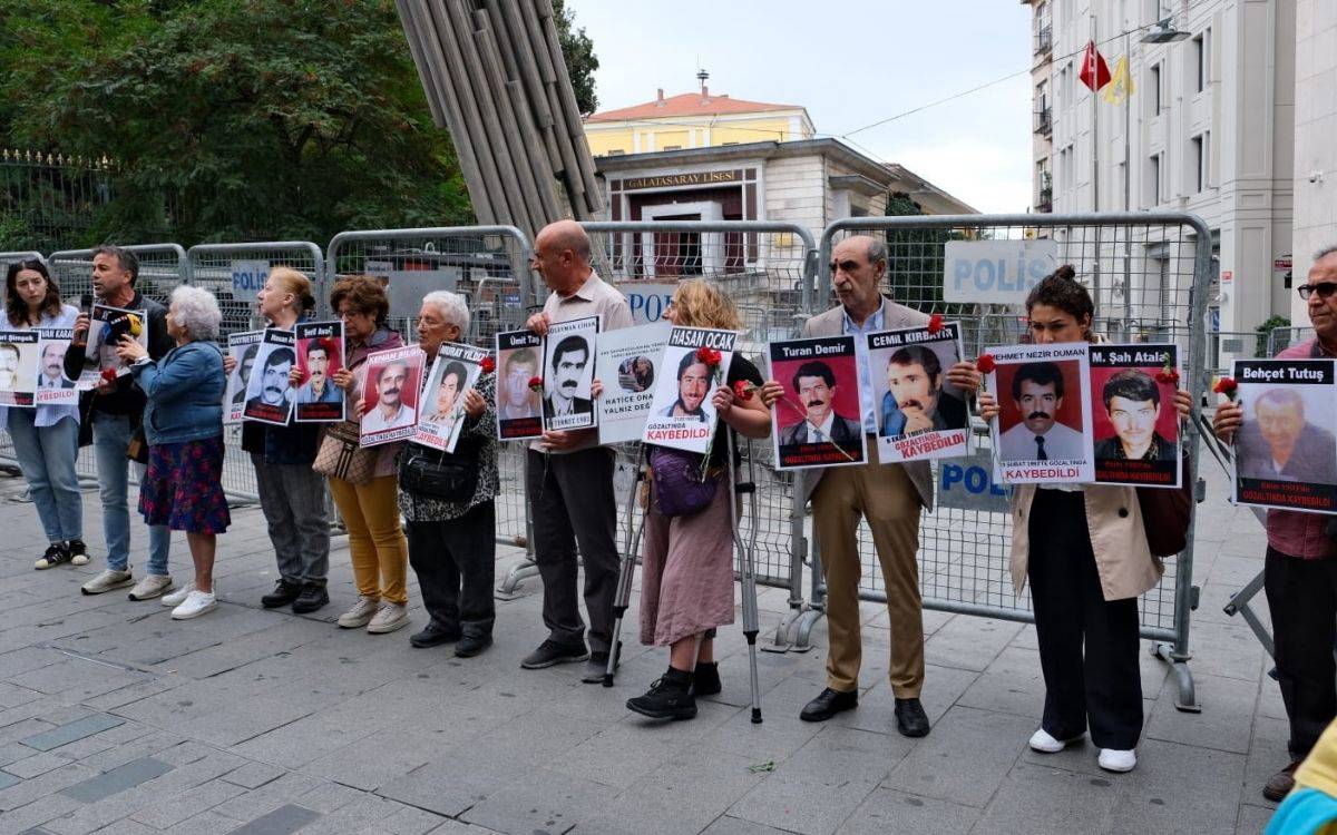 ChatGPT Bu fotoğraf, Cumartesi Anneleri’nin düzenlediği bir etkinlik veya protesto sırasında çekilmiş gibi görünüyor. Görselde, bir dizi kişi ellerinde kaybedilen yakınlarının fotoğraflarını tutuyor. Her bir fotoğrafta, kaybolan kişilerin isimleri, resimleri ve "gözaltında kaybedildi" yazısı dikkat çekiyor. Kişiler genellikle yaşlı ve orta yaş grubunda, ancak genç katılımcılar da var. Bazı katılımcılar posterlerin yanına kırmızı karanfiller de iliştirmiş. Bu da genellikle kayıpları anma ve adalet talebini simgeliyor.  Fotoğrafın çekildiği yer, büyük ihtimalle bir açık alan ve polis barikatlarıyla çevrili bir bölge. Arka planda Galatasaray Lisesi'nin bir kısmı ve "Polis" yazılı bariyerler görünmekte. Bu, fotoğrafın İstanbul Galatasaray Meydanı’nda çekildiğini düşündürüyor. Genel olarak, bu fotoğraf, kaybedilen yakınları için adalet arayan insanların sessiz ve güçlü bir protestosunu simgeliyor.