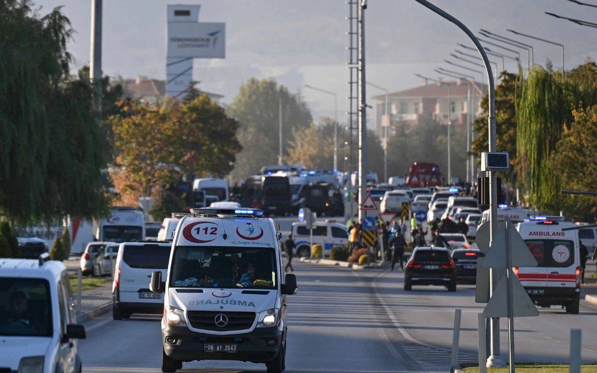 Fotoğraf, acil durum araçlarının yer aldığı yoğun bir yol kesitini göstermektedir. Önde 112 acil servis ambulansı, sirenlerini açmış şekilde ilerlerken, arkada çok sayıda polis ve ambulans aracı gözükmektedir. Yolun her iki tarafında araçlar ve acil müdahale ekipleri bulunmaktadır. Arka planda ağaçlarla çevrili bir bölge, binalar ve "Türk Havacılık ve Uzay Sanayii A.Ş." (TUSAŞ) logosunun yer aldığı bir yapı göze çarpmaktadır. Yoğunluk ve hareketlilik, acil bir olayın yaşandığını işaret etmektedir.