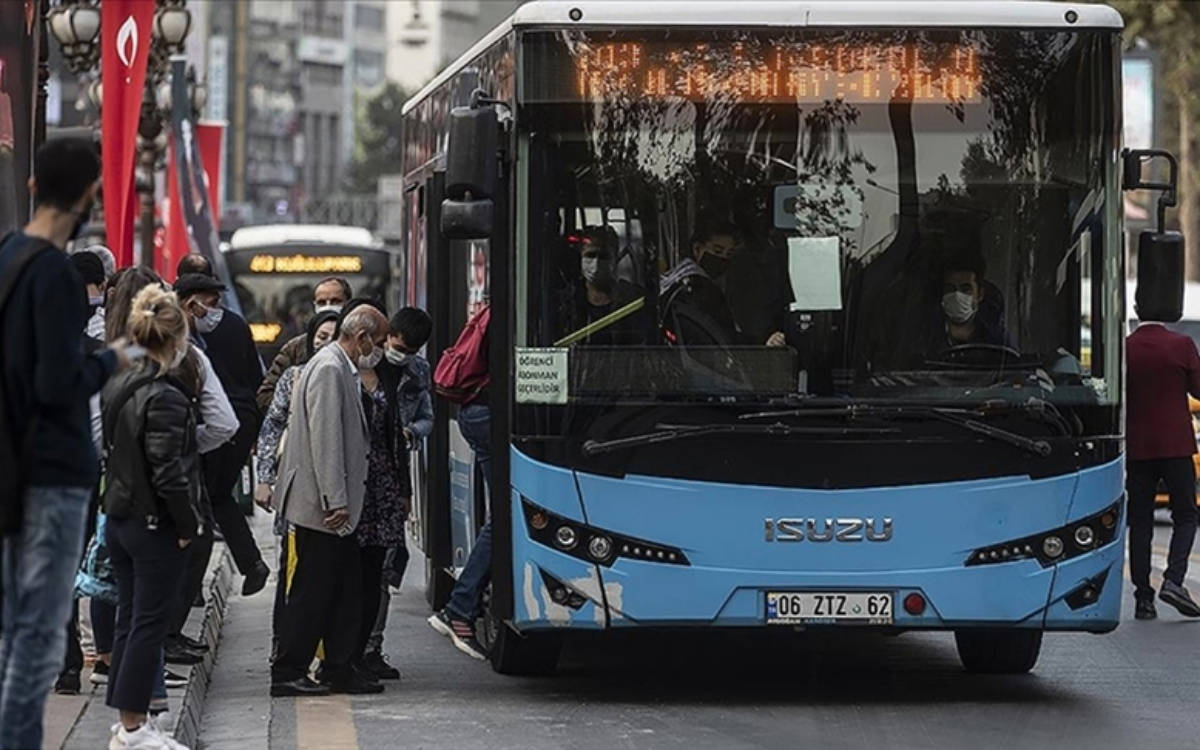 Fotoğrafta bir duraktan otobüse binen insanlar gözüküyor.