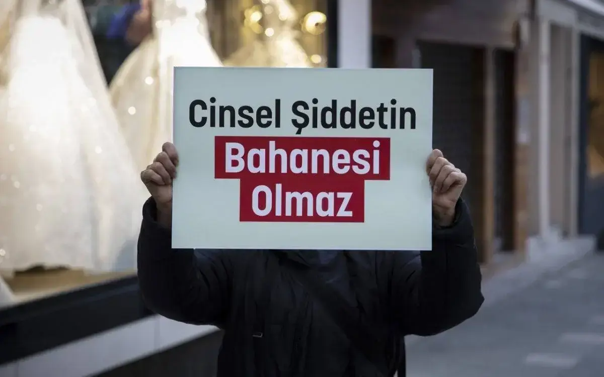 Görselde, bir kişi elinde bir pankart tutuyor. Pankartta "Cinsel Şiddetin Bahane Olmaz" yazısı yer alıyor. Yazının dikkat çekmesi için "Bahanesi Olmaz" kısmı kırmızı zemin üzerine beyaz renkte, diğer kısımlar ise siyah yazı ile yazılmış. Arka planda bir sokak görüntüsü ve vitrinler bulunuyor. Mesaj, cinsel şiddetin hiçbir koşulda mazur görülemeyeceğine dair bir farkındalık yaratmayı amaçlıyor.