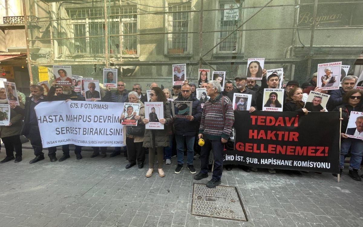 Fotoğrafta, İnsan Hakları Derneği (İHD) İstanbul Şubesi Hapishane Komisyonu tarafından düzenlenen 675. F Oturması sırasında yapılan bir basın açıklaması görülüyor.  Kalabalık bir grup, hasta mahpusların serbest bırakılması ve tedavi haklarının engellenmemesi için bir araya gelmiş. Önde büyük beyaz bir pankart taşıyan insanlar var, üzerinde "675. F Oturması – Hasta Mahpus Devrim Ayık Serbest Bırakılsın!" yazıyor. Sağ tarafta ise "Tedavi Haktır, Engellenemez!" yazılı siyah zemin üzerine kırmızı beyaz harflerle hazırlanmış başka bir pankart yer alıyor.  Katılımcılar, ellerinde hasta mahpusların fotoğraflarını taşıyan afişler tutuyor. Bu afişlerde mahpusların isimleri ve "Serbest Bırakılsın!" çağrıları yer alıyor. Çoğu katılımcının yüzü ciddi ve kararlı, bazıları hüzünlü bir ifadeyle duruyor. Çeşitli yaş gruplarından erkek ve kadınlardan oluşan topluluk, hasta mahpuslar için adalet talep ediyor.