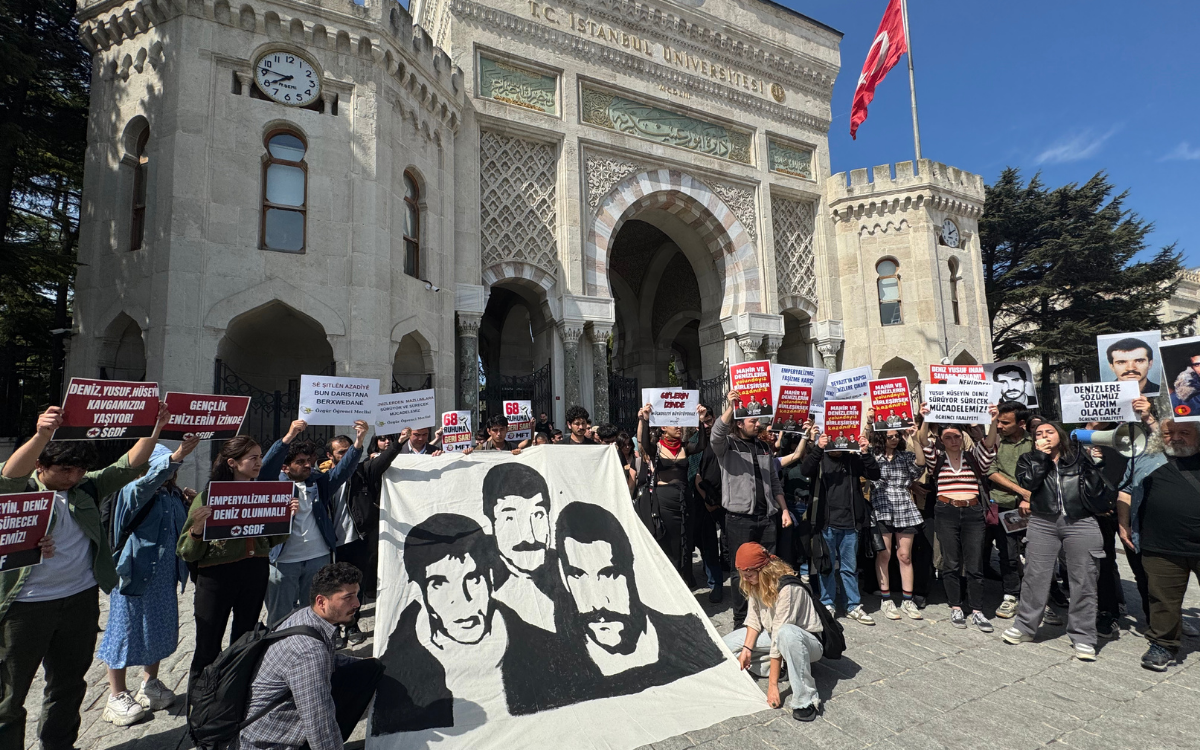 Fotoğrafta İstanbul Üniversitesi Ana Kapı önünde ellerinde dövizlerle kalabalık öğrenci grubu yer alıyor.