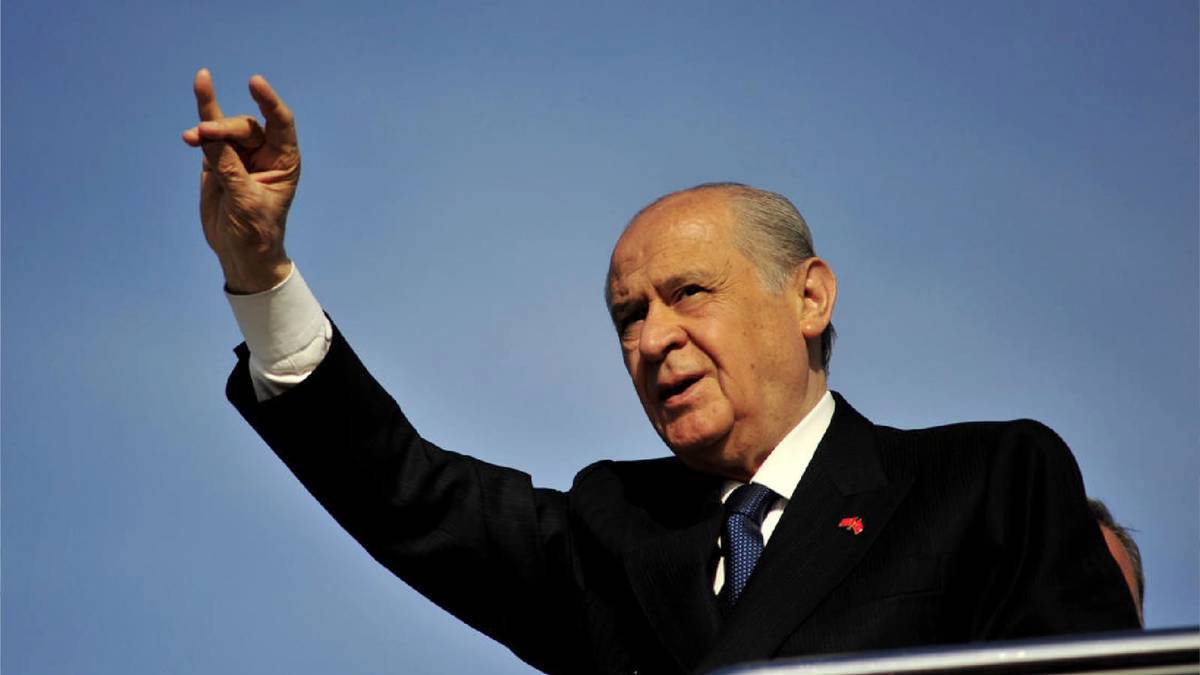 Arka planda kapalı bir iç mekân gibi görünüyor ve sanki bir sahne veya sunum ortamı olabilir.