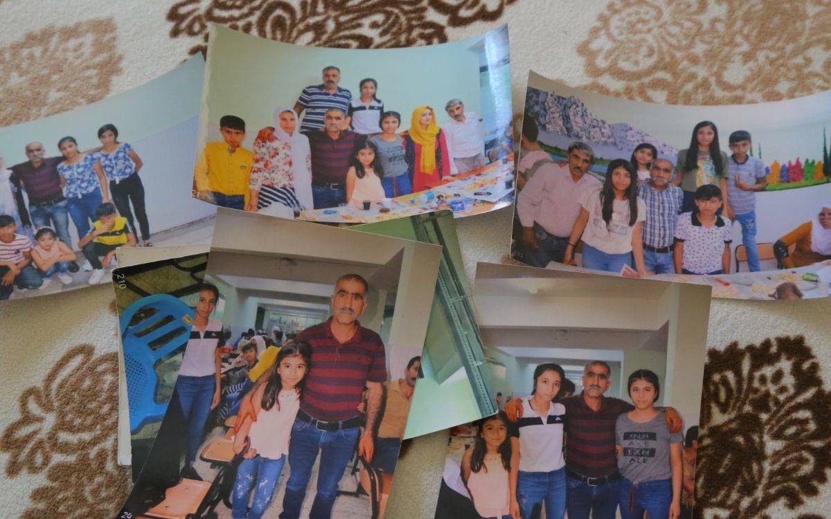 Bu fotoğraf, bir halının üzerine yerleştirilmiş altı ayrı basılı fotoğraf karesini göstermektedir. Fotoğrafların çoğunda benzer kişiler yer almakta ve muhtemelen bir aileye ya da yakın çevreye ait ziyaret anılarını belgelemektedir.