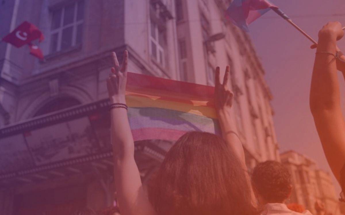 Bu fotoğraf, bir LGBTİ+ yürüyüşü ya da Onur Yürüyüşü (Pride) sırasında çekilmiş gibi görünüyor. Görsel, coşkulu bir toplumsal etkinliğin atmosferini yansıtıyor.