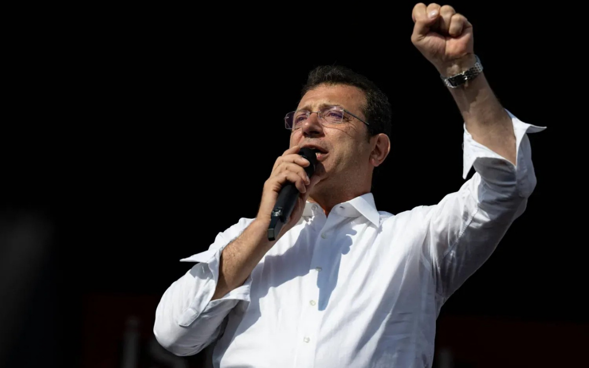 Ekrem İmamoğlu kolunu kaldırıyor.