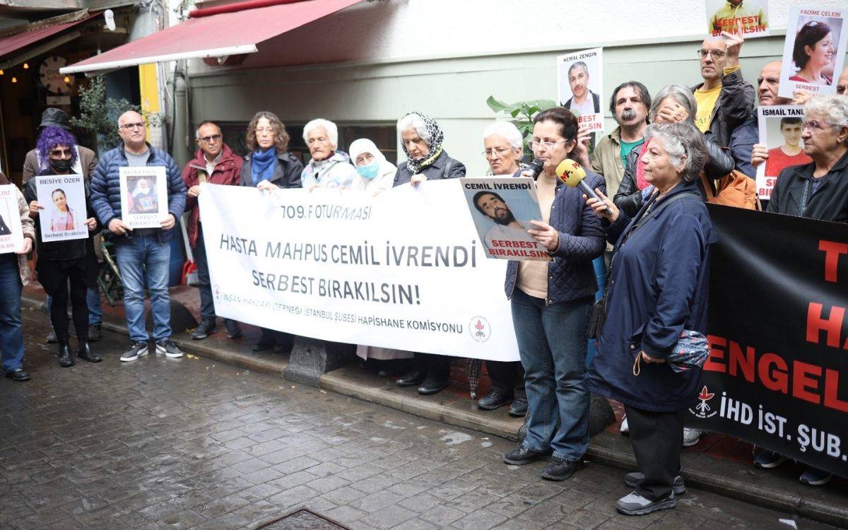 Dernek önünde ellerinde hasta mahpusların fotoğraflarını taşıyan insan hakları savunucuları var.