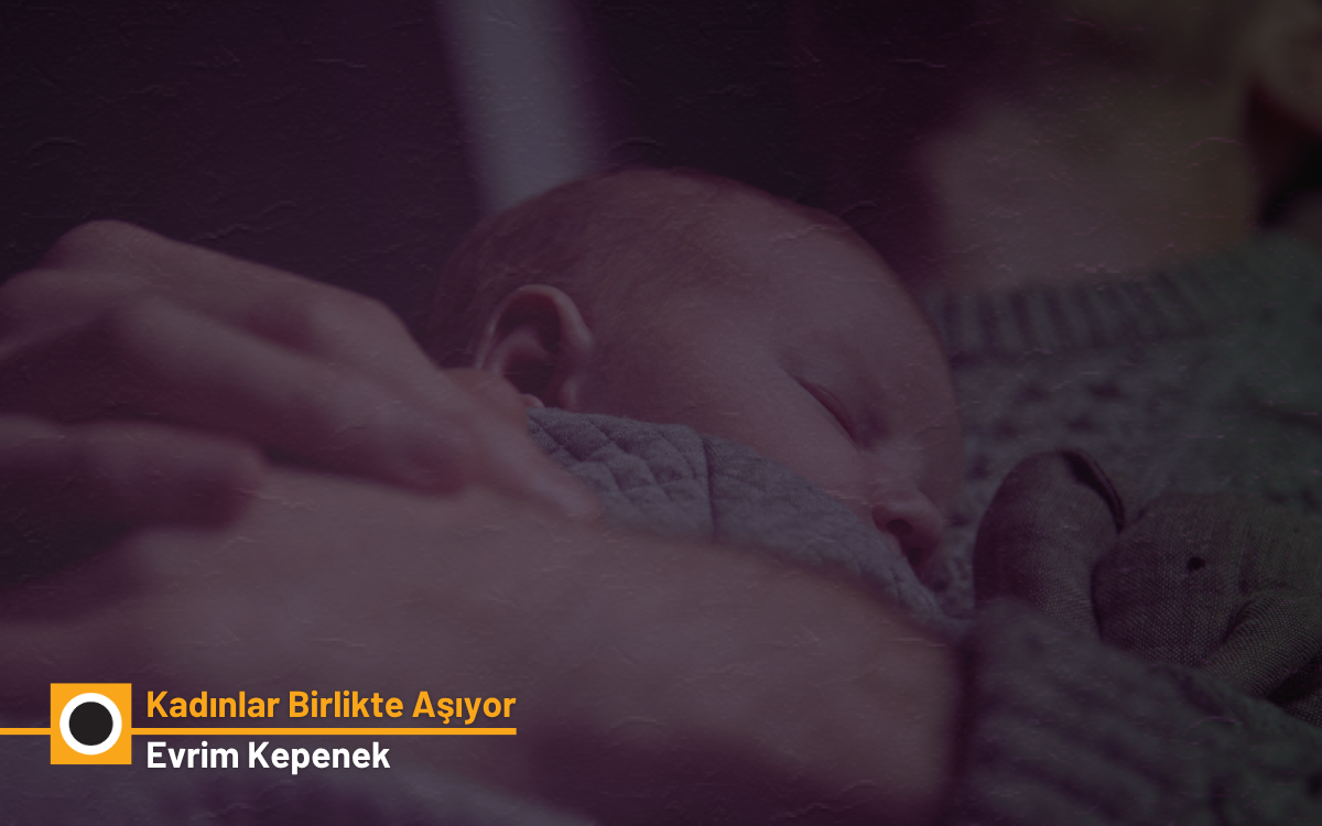 örselde, loş ve sıcak tonlarda çekilmiş bir fotoğraf yer alıyor. Ön planda, bir yetişkinin kolları arasında huzur içinde uyuyan bir bebek görülüyor. Bebeğin yüzü yana dönük, gözleri kapalı ve üzerine gri, yumuşak dokulu bir battaniye örtülmüş. Yetişkinin elleri, bebeği korur şekilde nazikçe sarıyor. Her ikisi de örgü desenli, kalın sayılabilecek kazaklar giyiyor; bu da fotoğrafa sıcak ve güvenli bir atmosfer katıyor. Sol alt köşede, bir grafik yerleşimi içinde şu yazılar bulunuyor: “Kadınlar Birlikte Aşıyor” – sarımsı turuncu tonlarda, Altında “Evrim Kepenek” – açık gri renkte. Bu kısım, muhtemelen bir yazı dizisinin veya bir haber görselinin kapak tasarımı. Fotoğraf genel olarak şefkati, korunmayı ve sakinliği yansıtan duygusal bir atmosfer taşıyor.