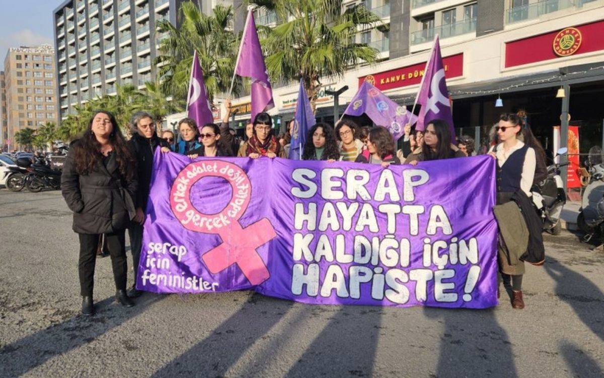 Görselde kalabalık bir kadın dayanışması protestosu görülüyor. Katılımcıların büyük bölümü kadınlardan oluşan bir topluluk ve mor renk hâkim.  Pankart ve mesajlar  En önde geniş mor bir pankart taşınıyor.  Pankartın üzerinde büyük harflerle şu slogan yazılı: “SERAP HAYATTA KALDIĞI İÇİN HAPİSTE!”  Slogan, hayatta kalmak adına özsavunma hakkı kullanan bir kadının hapsedilmesine itiraz niteliğinde.  Sol tarafta da pembe/kırmızı tonlarında bir cinsiyet eşitliği sembolü (♀ - feminist simgesi) ve çevresinde “Gerçek adalet değil erkek adalet!” cümlesi yer alıyor.