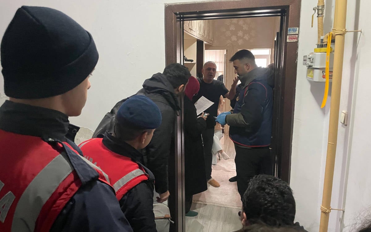 Apartman dairesinin girişinde çekilen bu fotoğrafta Mehmet Türkmen, açık kapının hemen arkasında duruyor. Jandarma ise içeriye girmek için kapıda bekliyor.