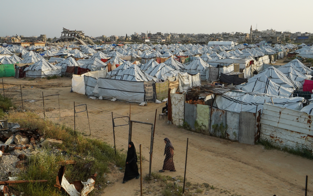 Fotoğrafta Gazze'deki Nuseyrat Kampı gözüküyor. Ön tarafta çadırlar, arkada ise yıkılmış bir kent gözüküyor.