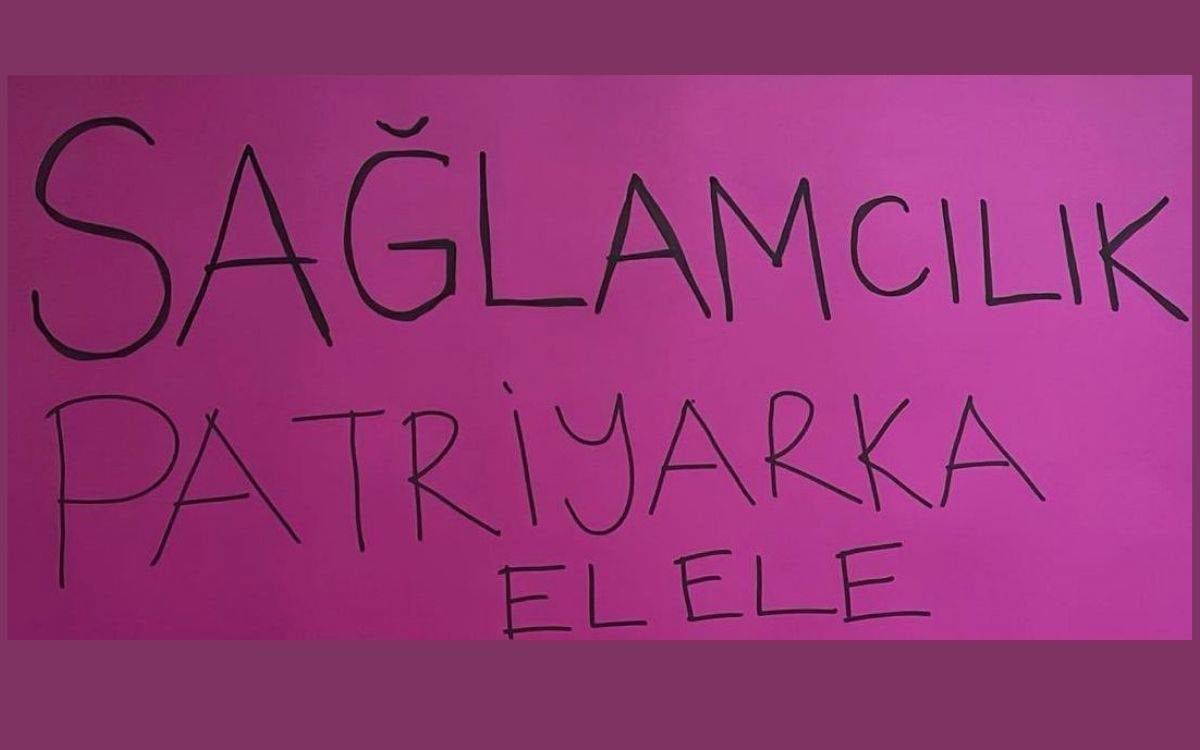 Görselde, mor bir fon üzerine yazılmış bir slogan yer alıyor: "SAĞLAMCILIK PATRIYARKA ELELE". Yazı, büyük harflerle el yazısı tarzında yazılmış. Mesaj, sağlamcılık (ableizm) ve ataerkil düzenin birbirini destekleyen yapılar olduğuna vurgu yapıyor. Bu tür bir yazı genellikle sosyal farkındalık veya aktivizm kapsamında bir protesto ya da etkinlikte kullanılan bir pankart olabilir. Arka planın düz ve mor olması mesajı daha net ve belirgin kılıyor.