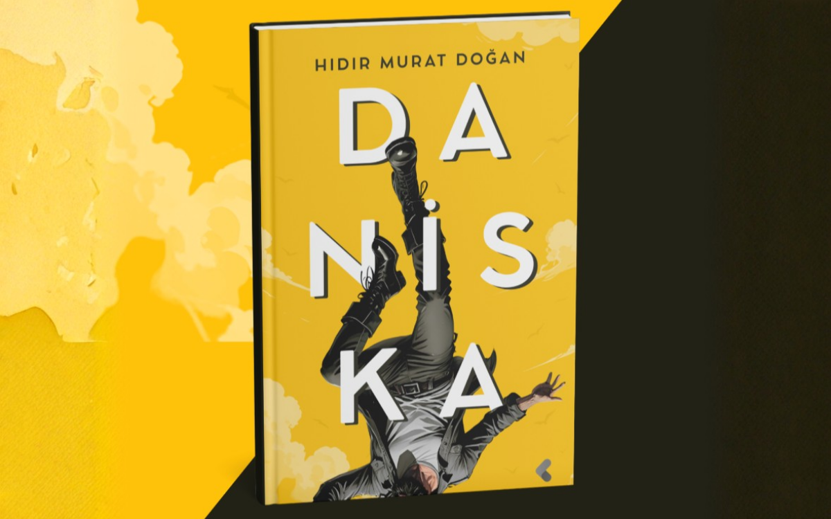 Görselde sarı tonların hâkim olduğu bir kitap kapağı yer alıyor. Kitabın adı “Daniska”, yazarın adı ise üst kısımda “Hıdır Murat Doğan” olarak yazılmış. Kapakta, gökyüzü fonu önünde ters dönmüş bir insan figürü görülüyor;